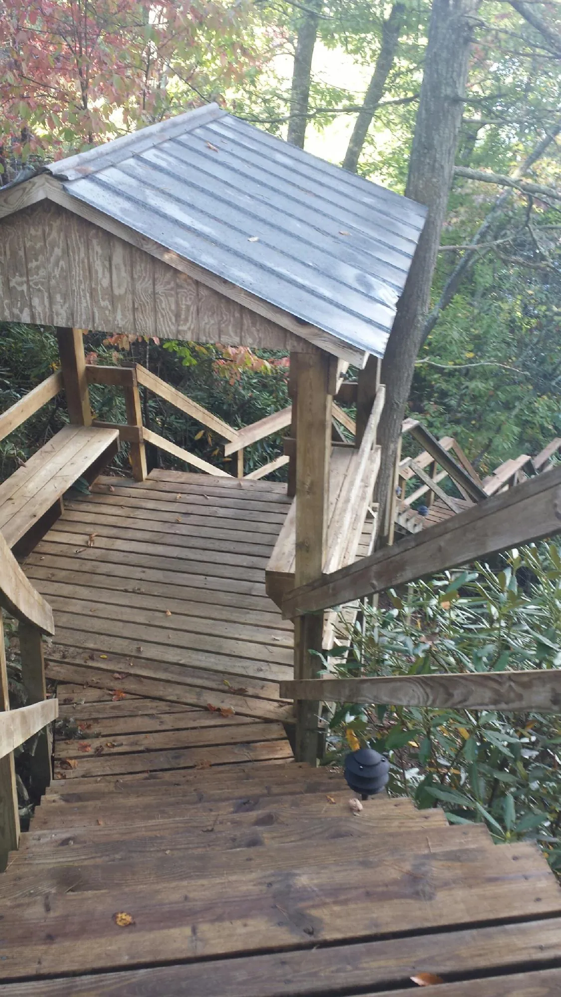 Metal roofed shelter over wooden steps on a wooded walkway — Skylight Repair & Installation work by our crew in Providence Forge