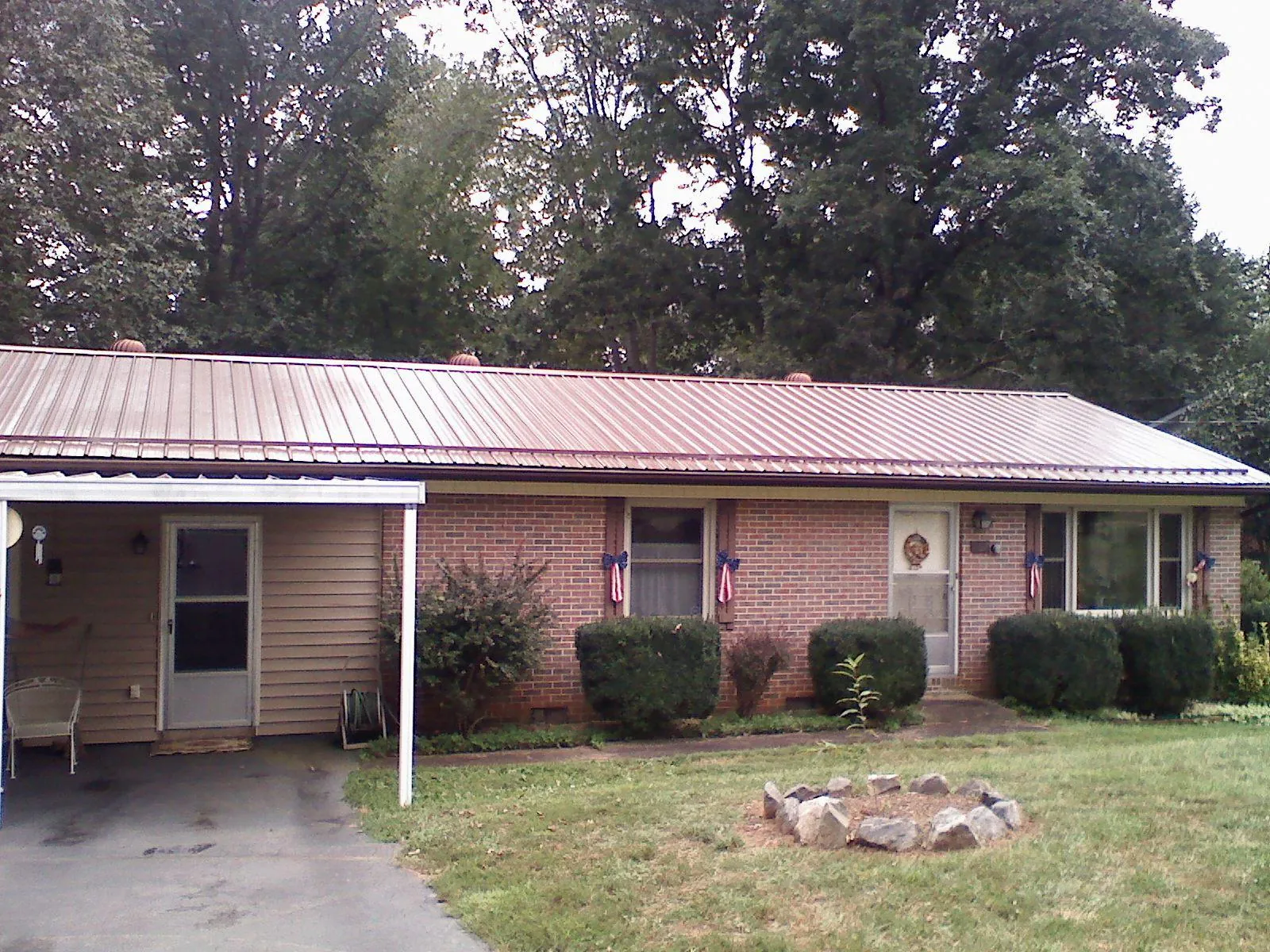 Bronze metal roof and carport on a brick ranch home — Roof Repair work by our crew in Providence Forge